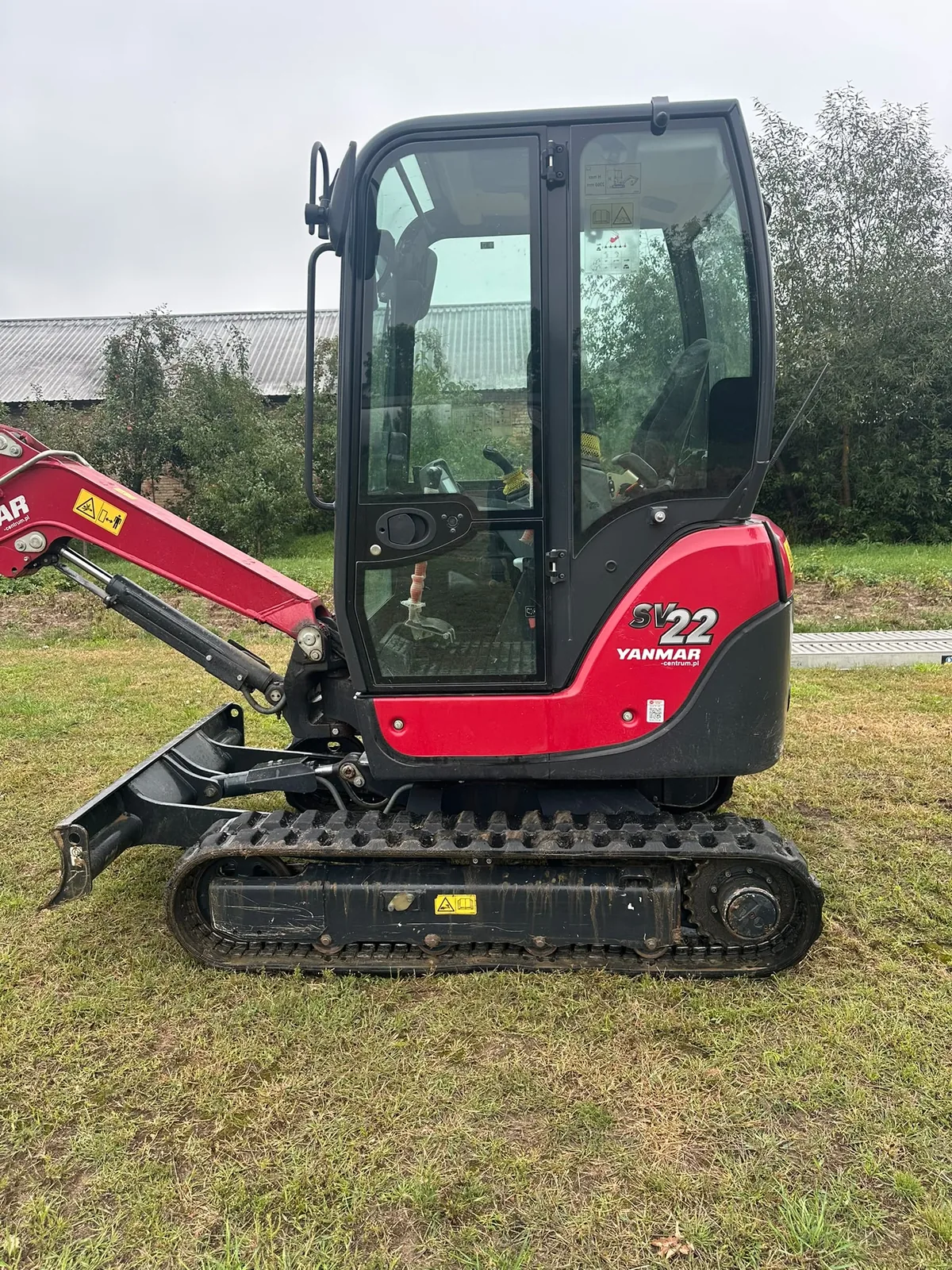 Minikoparka Yanmar SV22 — widok z boku na kabinę i gąsienice