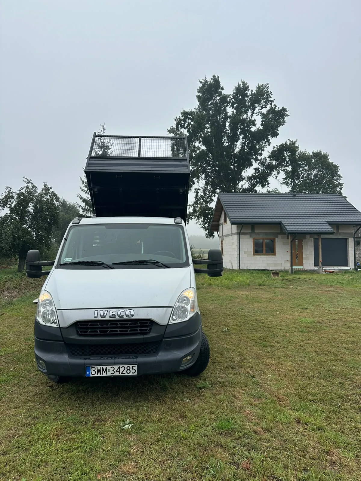 Bus z wywrotką z podniesioną skrzynią — widok od przodu